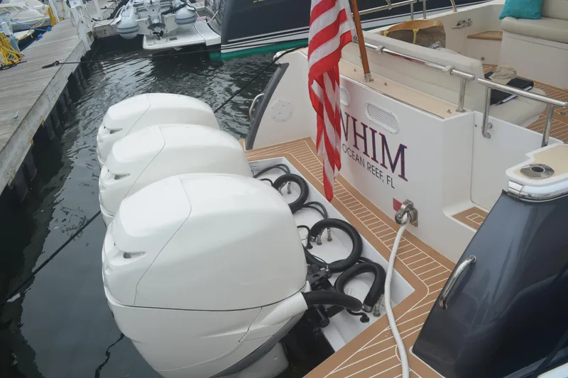 Slide: The Image of 2020 MJM 43z boat with triple outboard engines docked at marina. - 57
