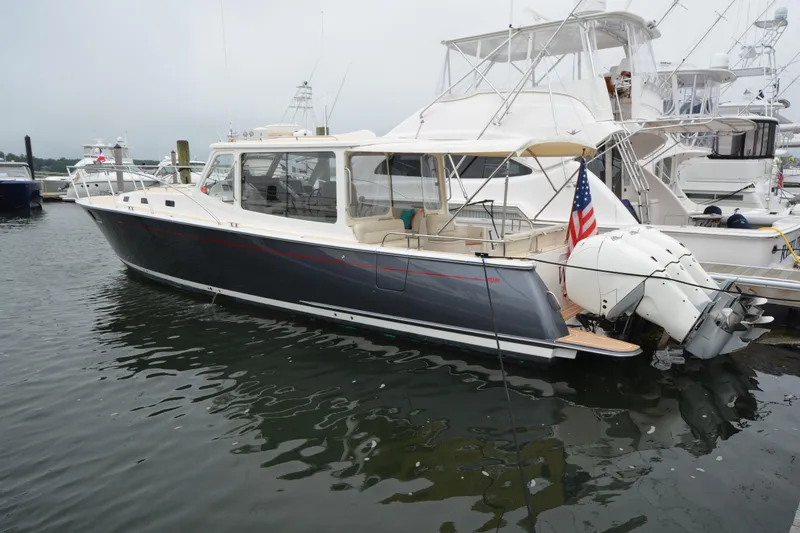 Slide: The Image of 2020 MJM 43z yacht docked, featuring sleek design and powerful outboard engines. - 6