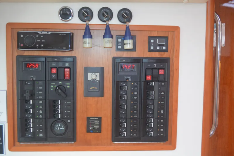 Slide: The Image of Electrical control panel on a 2020 MJM 43z boat, featuring various switches and gauges. - 61