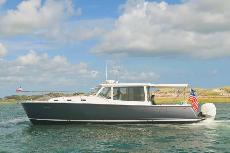 Slide: The Image of 2020 MJM 43z boat cruising on water under a partly cloudy sky. - 62