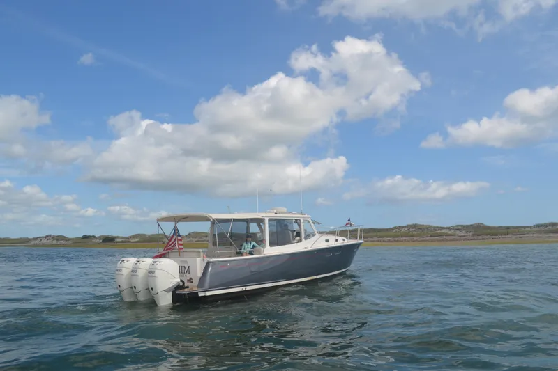 Slide: The Image of 2020 MJM 43z boat cruising on water under a clear blue sky. - 63
