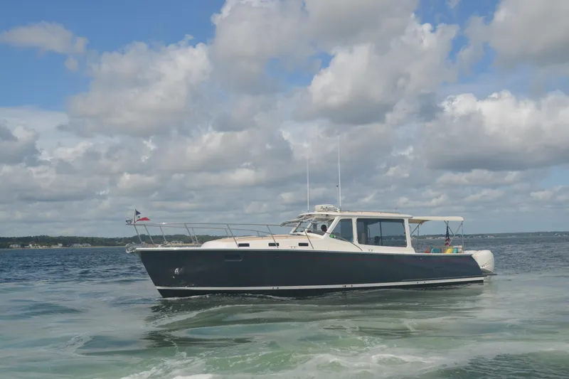 Slide: The Image of 2020 MJM 43z boat cruising on open water under a cloudy sky. - 65