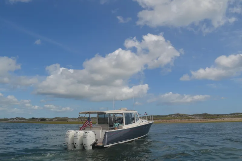 Slide: The Image of 2020 MJM 43z boat cruising on open water under a clear blue sky. - 66