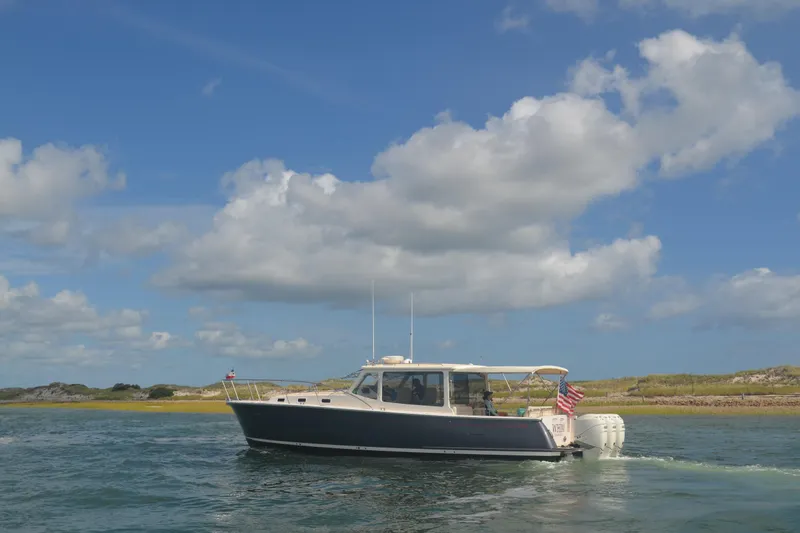 Slide: The Image of 2020 MJM 43z boat cruising on a sunny day with blue skies and clouds. - 68