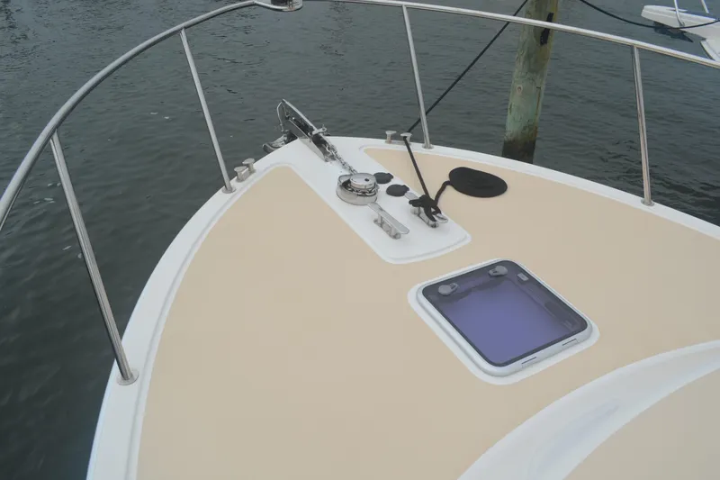Slide: The Image of 2020 MJM 43z boat deck with anchor and hatch, docked on calm water. - 8