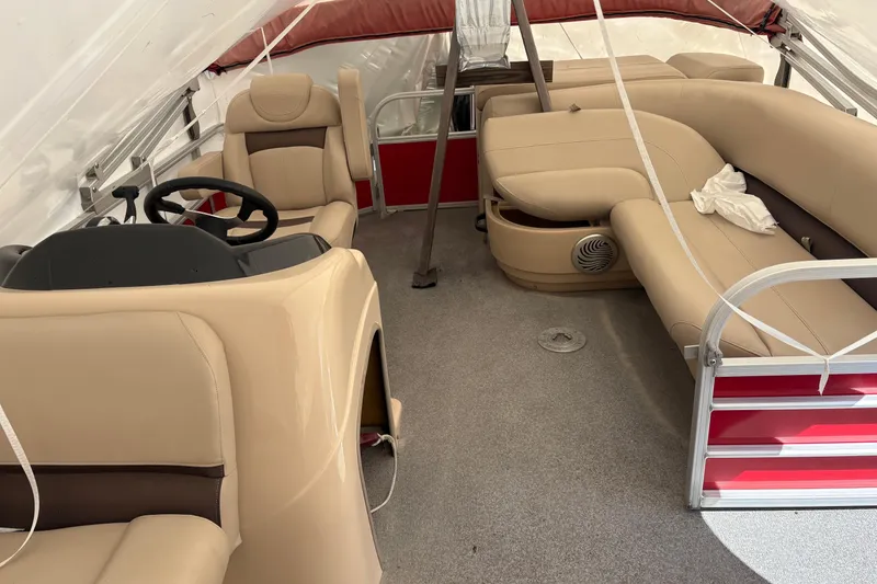 Slide: The Image of 2017 Sun Tracker Party Barge 20 DLX interior with beige seating and steering console. - 2