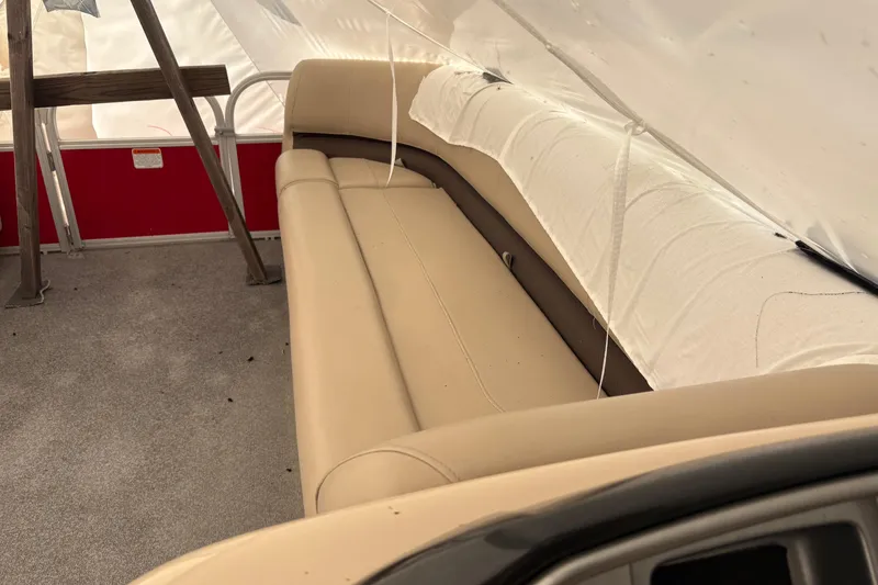 Slide: The Image of 2017 Sun Tracker Party Barge 20 DLX interior with beige seating under cover. - 4