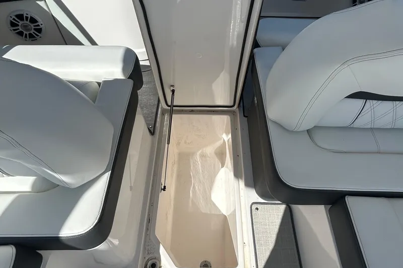 Slide: The Image of 2023 Regal LX6 boat interior with open storage compartment and cushioned seating. - 13