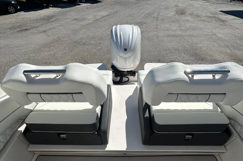 Slide: The Image of 2023 Regal LX6 boat interior with white cushioned seats and outboard motor. - 14