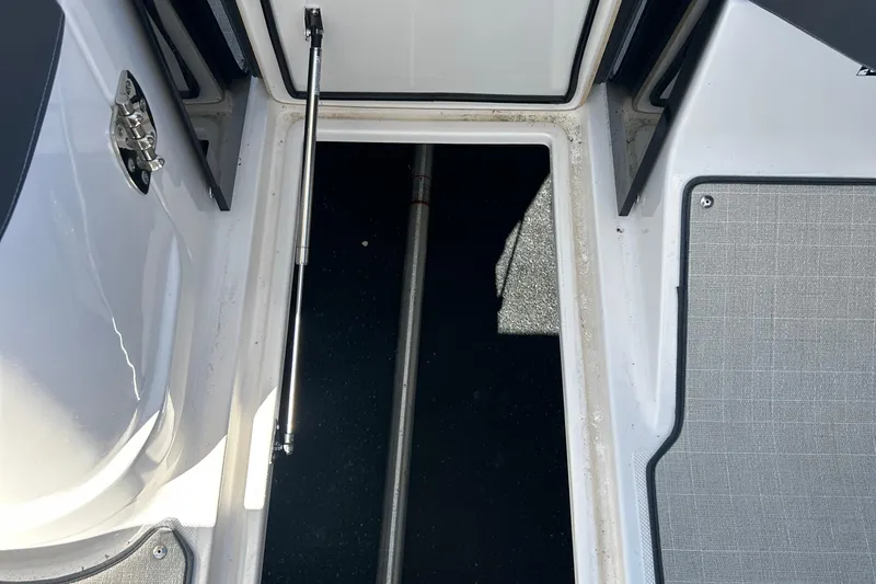 Slide: The Image of 2023 Regal LX6 boat storage compartment with open hatch and hydraulic lift. - 15