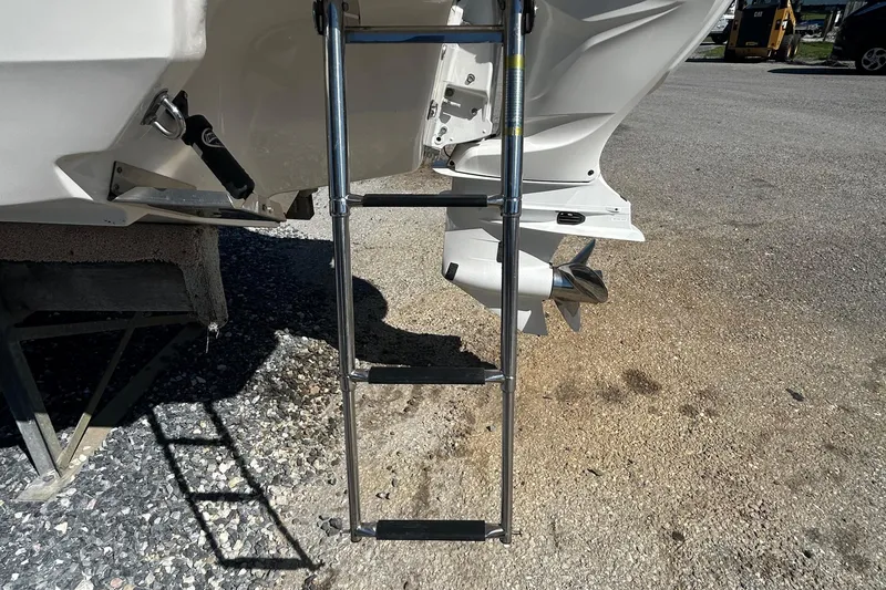 Slide: The Image of 2023 Regal LX6 boat with extended ladder and visible propeller on gravel surface. - 18