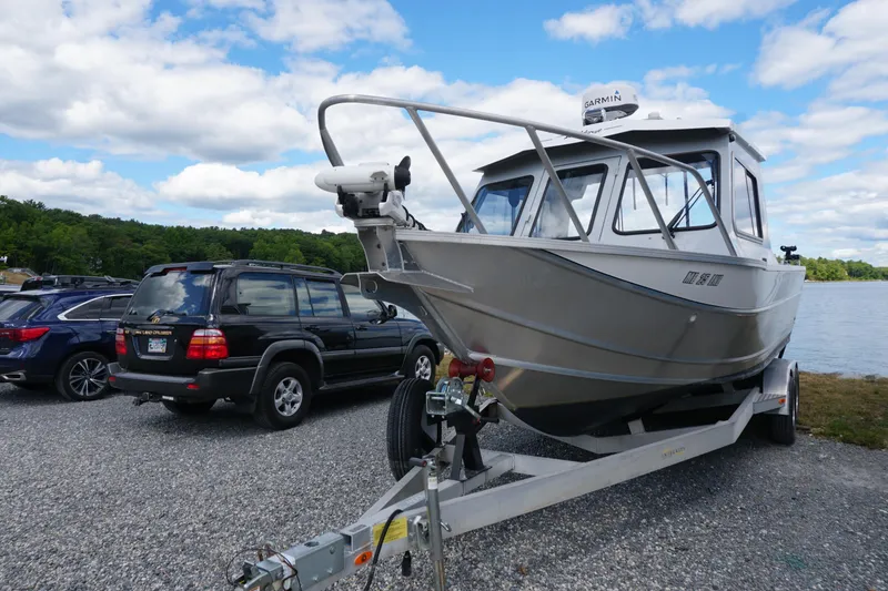 Slide: The Image of 2023 Weldcraft Ocean King 220 boat on trailer near parked cars by a lake. - 17