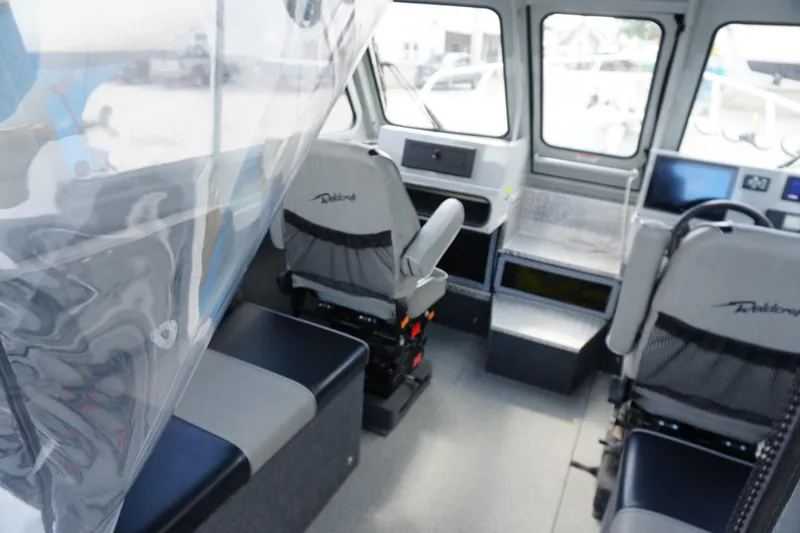 Slide: The Image of Interior of 2023 Weldcraft Ocean King 220 boat, featuring seating and navigation equipment. - 29