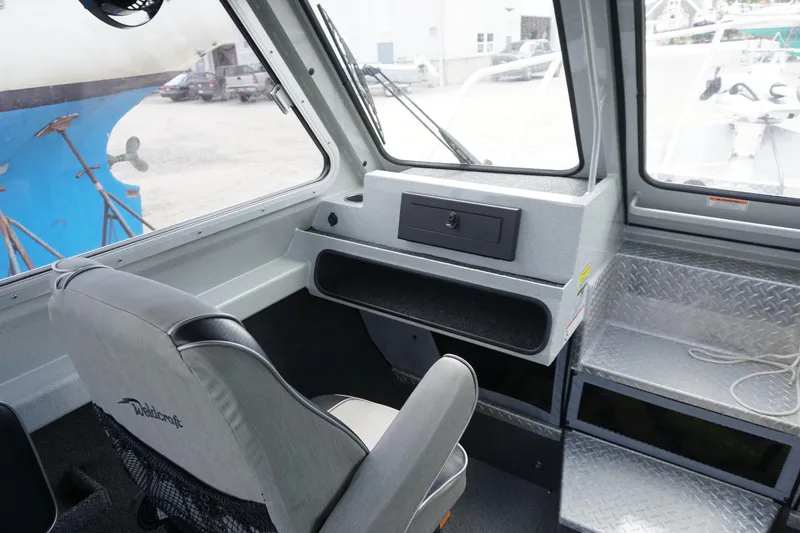 Slide: The Image of Interior of 2023 Weldcraft Ocean King 220 boat, featuring helm and seating area. - 32