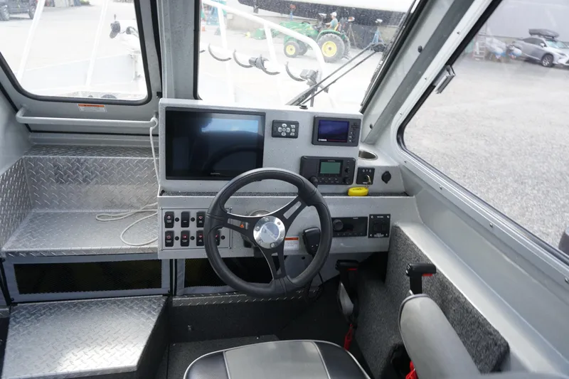 Slide: The Image of 2023 Weldcraft Ocean King 220 boat cockpit with steering wheel and navigation controls. - 36