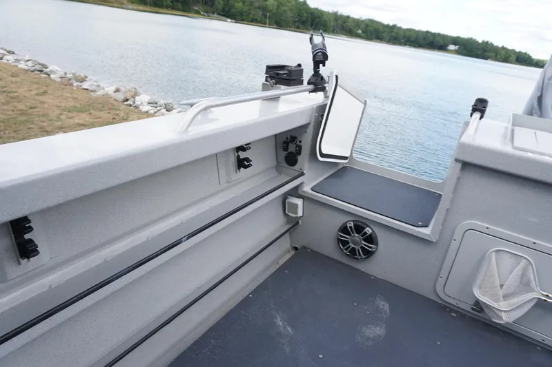 Slide: The Image of 2023 Weldcraft Ocean King 220 boat interior with fishing rod holders and speaker, near a lake. - 46