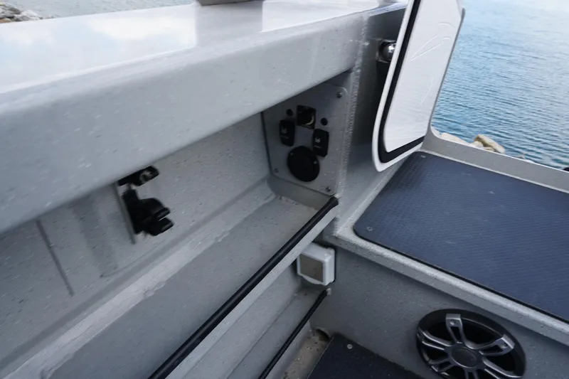 Slide: The Image of 2023 Weldcraft Ocean King 220 boat interior with storage compartment and speaker, near water. - 47