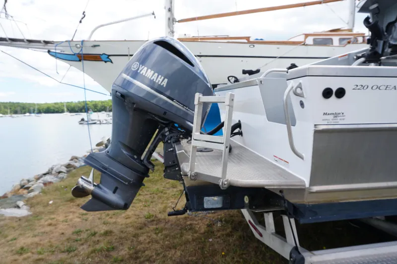 Slide: The Image of 2023 Weldcraft Ocean King 220 with Yamaha outboard motor, docked by a scenic waterfront. - 23