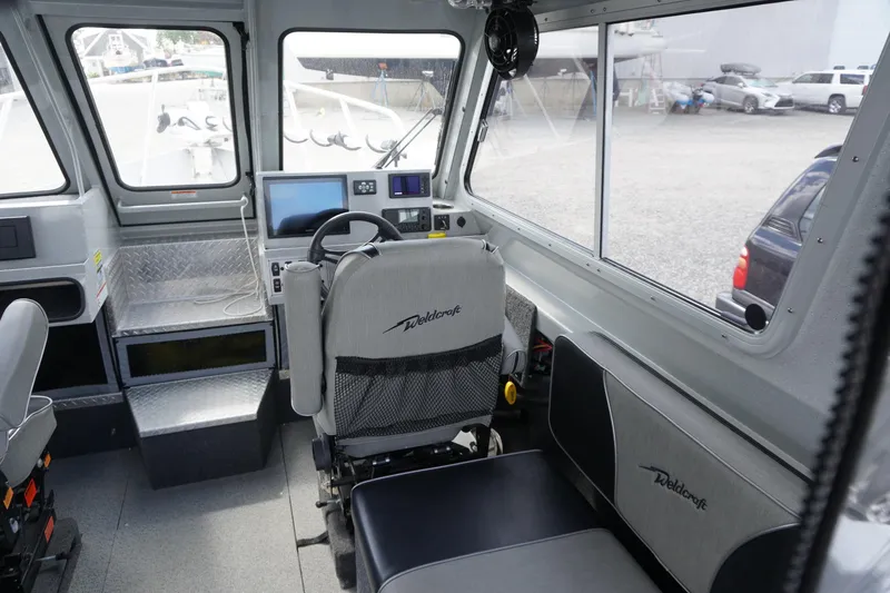 Slide: The Image of Interior of 2023 Weldcraft Ocean King 220 boat with modern controls and seating. - 30