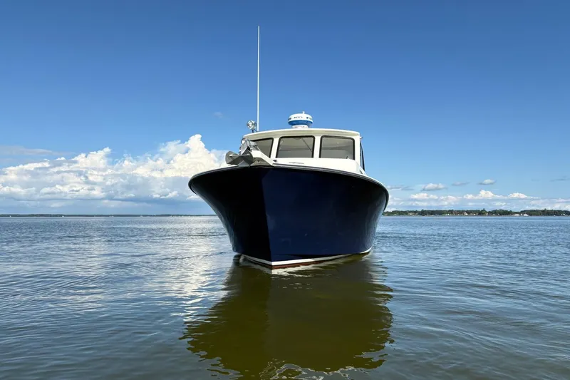 Slide: The Image of 2021 Composite Yacht CY32 Chesapeake on calm water under clear blue sky. - 2