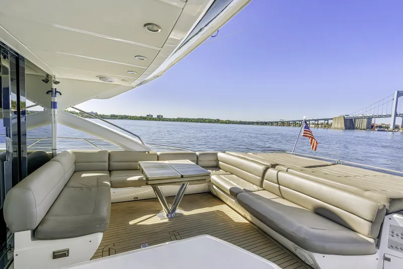Slide: The Image of Luxurious 2014 Sunseeker 68 Sport Yacht deck with seating, table, and scenic water view. - 9