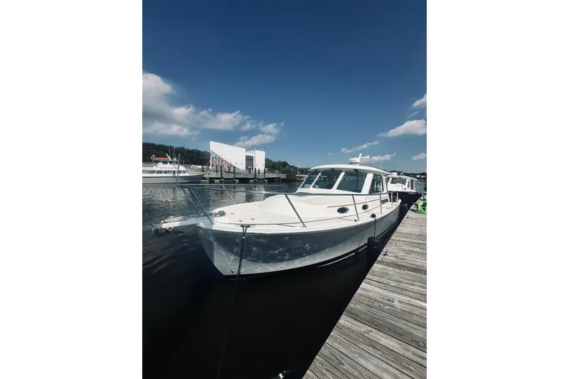Slide: The Image of 2013 Back Cove 30 boat docked under a clear blue sky. - 11
