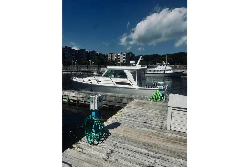 Slide: The Image of 2013 Back Cove 30 boat docked at a marina with clear skies. - 12