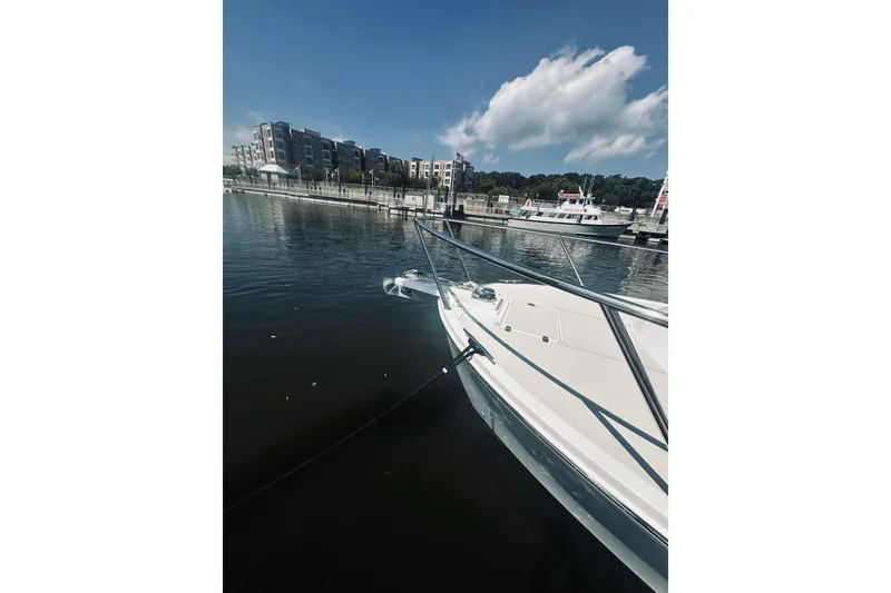 Slide: The Image of 2013 Back Cove 30 boat docked in a marina with buildings in the background. - 14