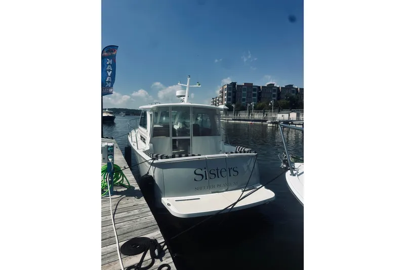 Slide: The Image of 2013 Back Cove 30 boat docked at marina, clear sky, waterfront buildings. - 15