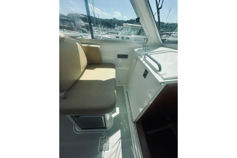 Slide: The Image of Interior of 2013 Back Cove 30 boat with beige seating and window view. - 21