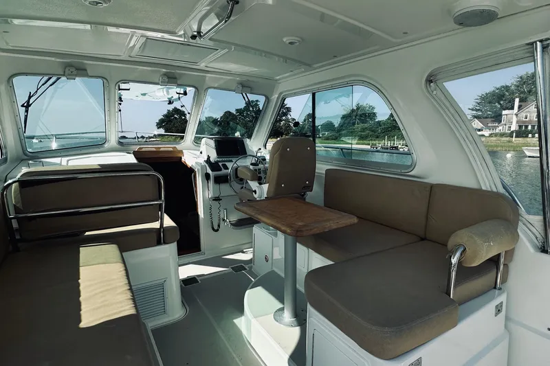 Slide: The Image of Interior of 2013 Back Cove 30 boat with seating and helm, overlooking scenic waterway. - 22