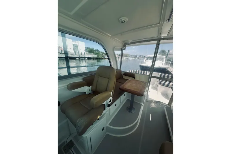 Slide: The Image of 2013 Back Cove 30 interior with leather seating and wooden table, dockside view. - 23