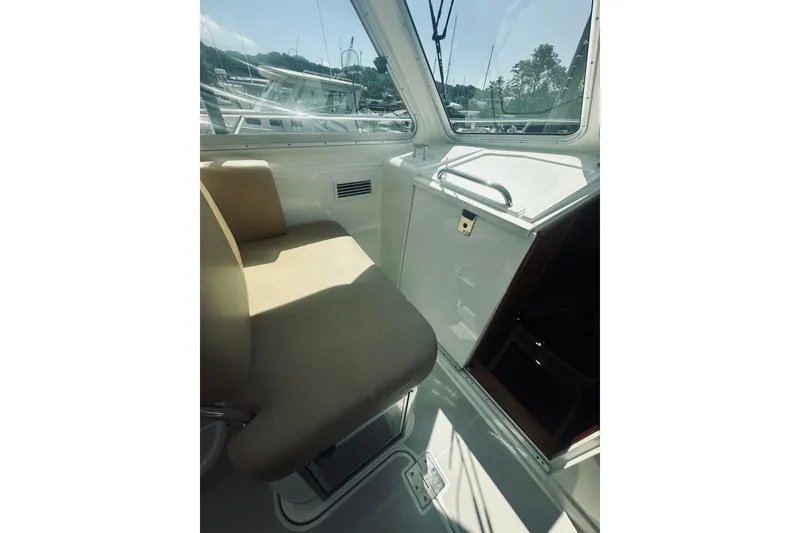 Slide: The Image of Interior of 2013 Back Cove 30 boat with beige seating and window view. - 24