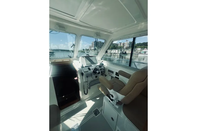 Slide: The Image of Interior view of 2013 Back Cove 30 boat, featuring helm and seating area. - 31