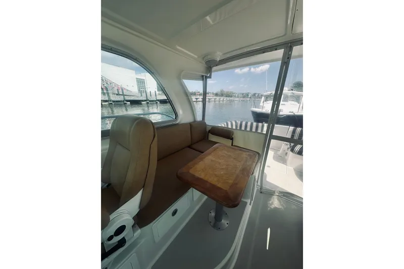 Slide: The Image of Interior view of 2013 Back Cove 30 boat with seating and table by the water. - 33