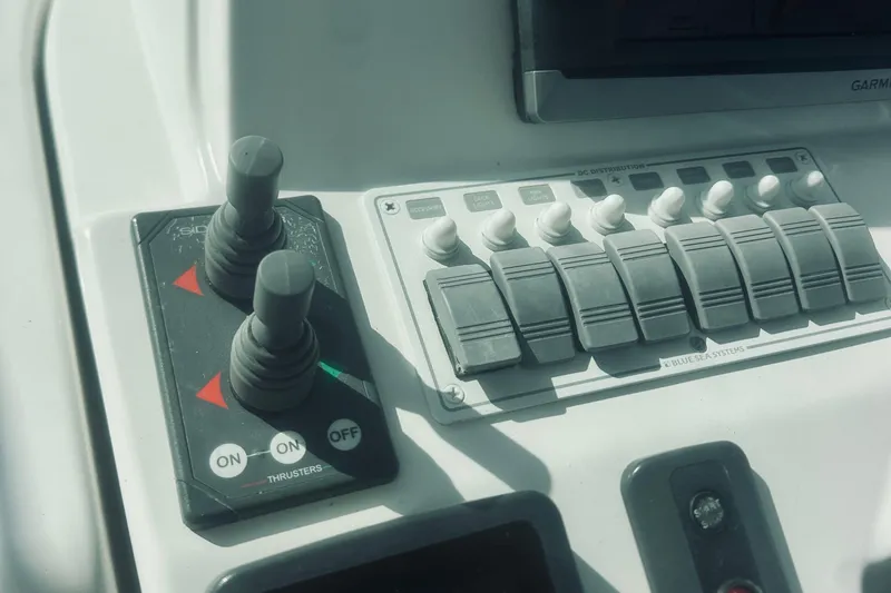 Slide: The Image of Control panel of a 2013 Back Cove 30 boat with switches and thruster controls. - 35