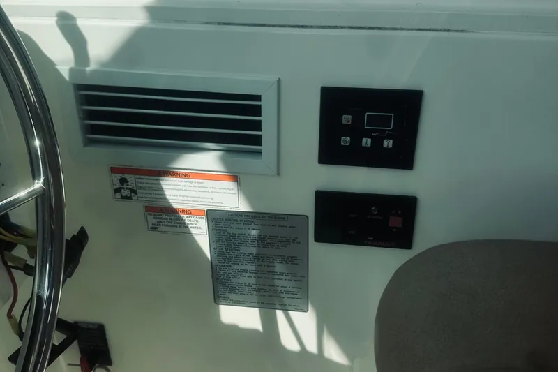 Slide: The Image of Control panel and warning labels on a 2013 Back Cove 30 boat dashboard. - 37