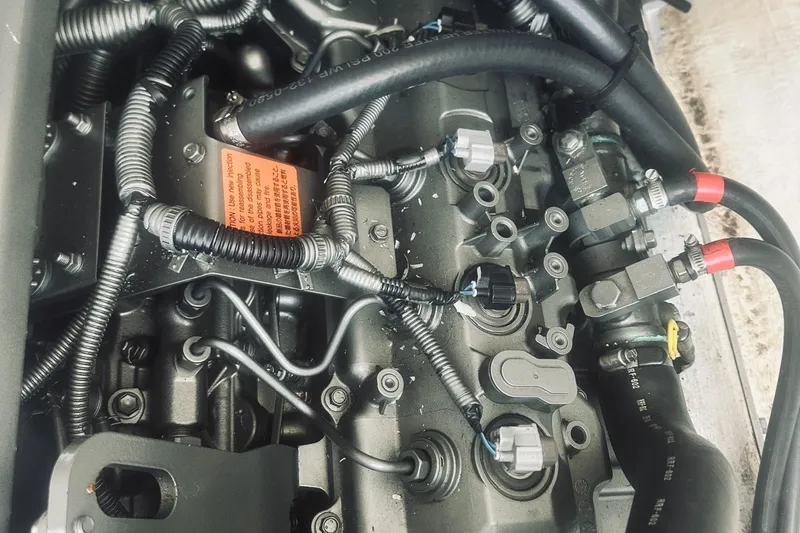 Slide: The Image of Engine components of a 2013 Back Cove 30 boat, featuring intricate wiring and hoses. - 43