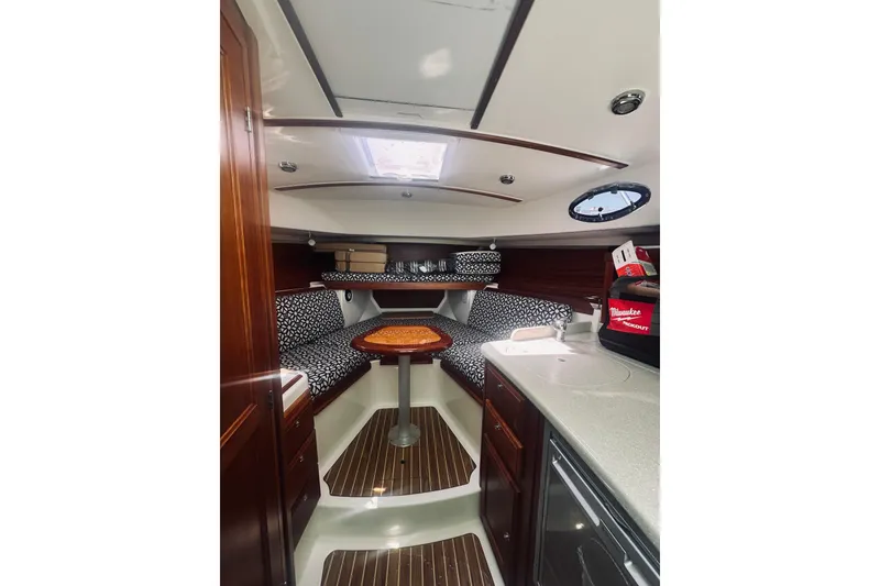 Slide: The Image of 2013 Back Cove 30 interior with wood accents, patterned seating, and compact kitchenette. - 46