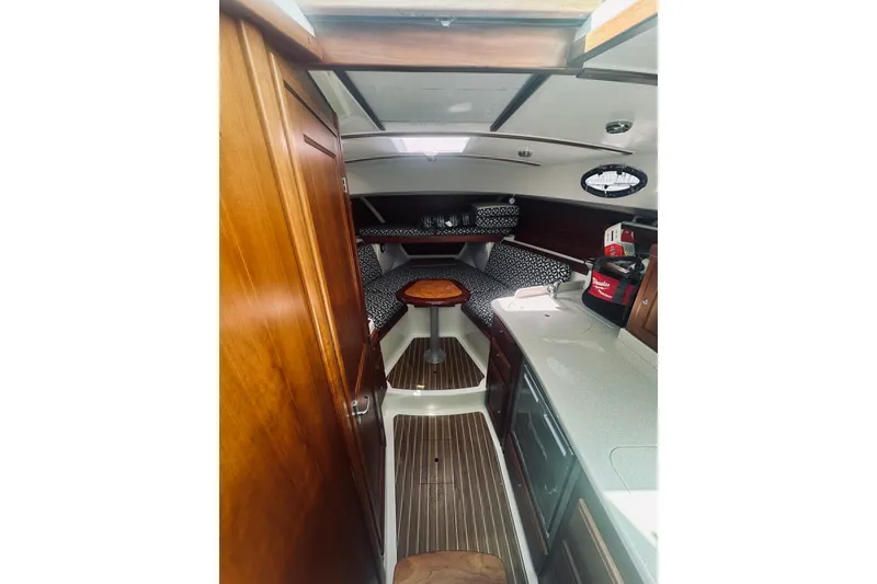 Slide: The Image of 2013 Back Cove 30 boat interior with wood finish, compact kitchen, and cozy seating area. - 47