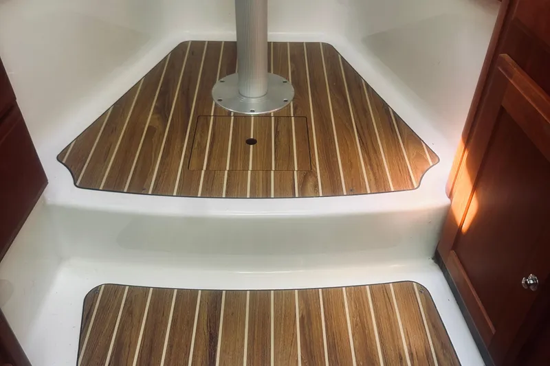 Slide: The Image of 2013 Back Cove 30 boat interior with wood-patterned flooring and white steps. - 53