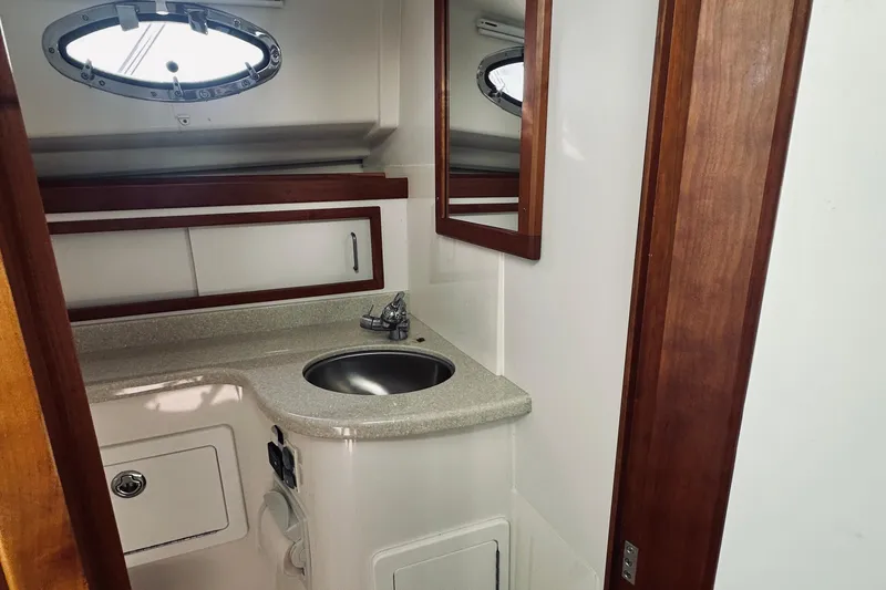 Slide: The Image of 2013 Back Cove 30 yacht bathroom with sink, mirror, and wooden accents. - 56