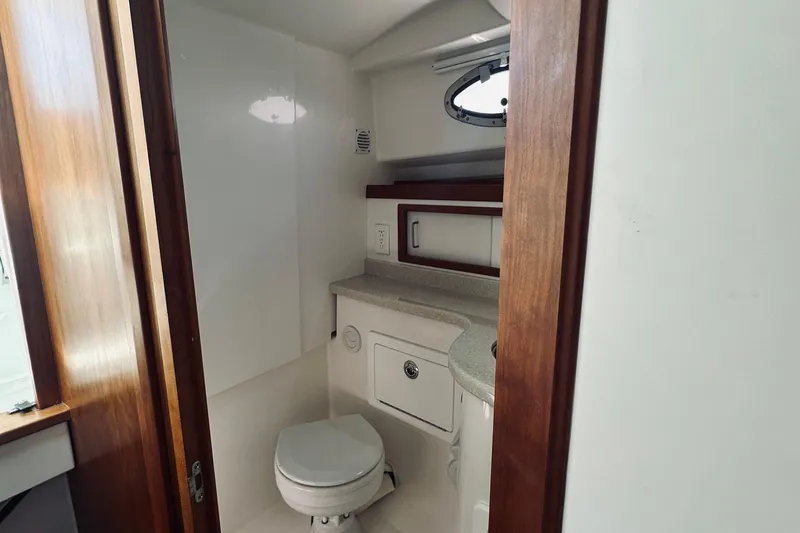Slide: The Image of 2013 Back Cove 30 yacht bathroom with toilet, sink, and wooden accents. - 57