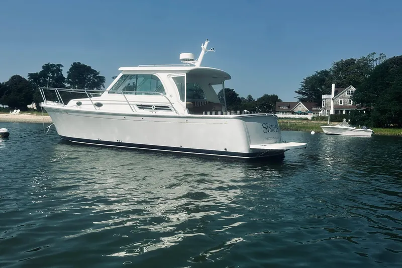 Slide: The Image of 2013 Back Cove 30 boat on calm water near shoreline homes. - 6