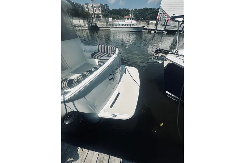 Slide: The Image of 2013 Back Cove 30 boat docked at marina with striped seating. - 65