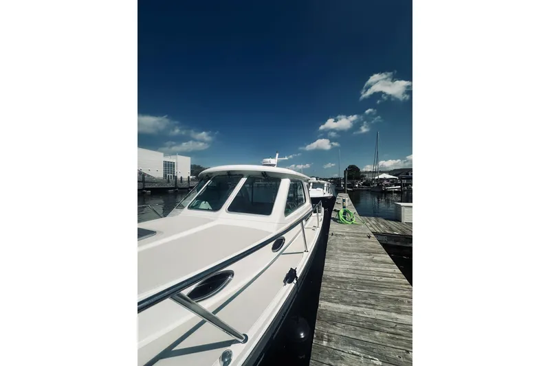 Slide: The Image of 2013 Back Cove 30 boat docked at marina under clear blue sky. - 8