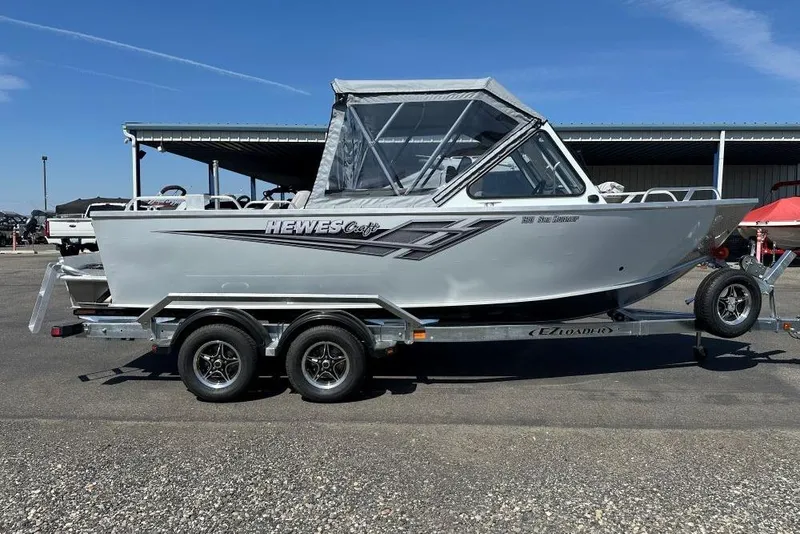 Slide: The Image of 2025 Hewescraft 190 Sea Runner ET boat on trailer, parked outdoors. - 2