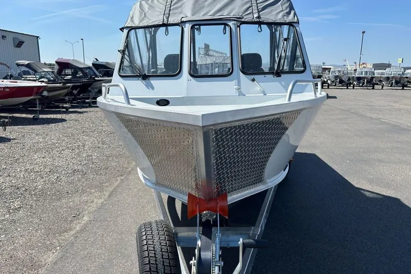 Slide: The Image of 2025 Hewescraft 190 Sea Runner ET boat on trailer, parked outdoors. - 3