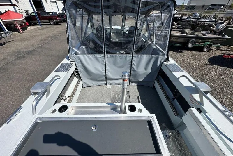 Slide: The Image of 2025 Hewescraft 190 Sea Runner ET boat interior with canopy, docked outdoors. - 5