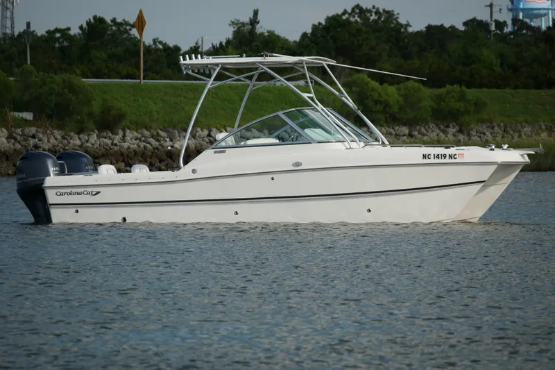 Slide: The Image of 2014 Carolina Cat 23DC boat on calm water, side view. - 12